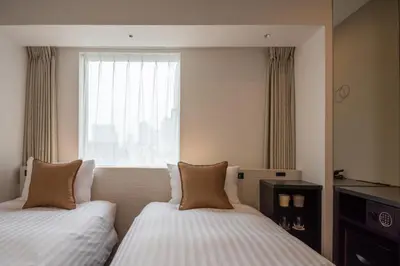 a hotel room with two beds and a window at Hotel Vista Tokyo Tsukiji in Tokyo