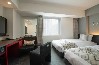 a hotel room with two beds and a television at Hotel Vista Tokyo Tsukiji in Tokyo