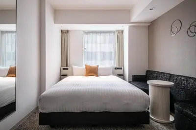 a hotel room with a bed and a couch at Hotel Vista Tokyo Tsukiji in Tokyo