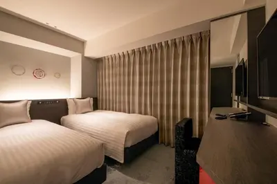 a hotel room with two beds and a television at Hotel Vista Tokyo Tsukiji in Tokyo