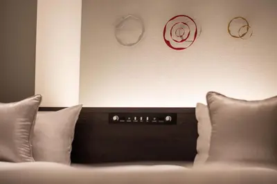 a room with a bed with pillows and a wall at Hotel Vista Tokyo Tsukiji in Tokyo