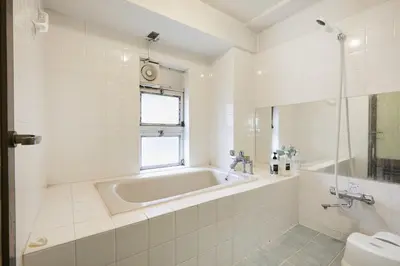 a white bathroom with a tub and a toilet at Miki Hall Akabane in Tokyo