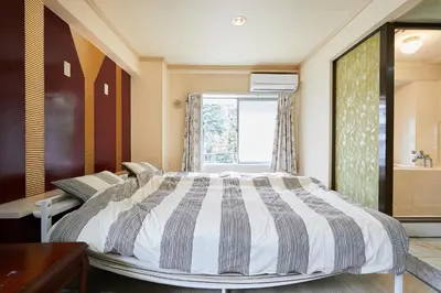 a bedroom with a large bed and a window at Miki Hall Akabane in Tokyo