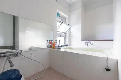 a white bathroom with a sink and a bath tub at Miki Hall Akabane in Tokyo