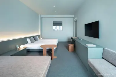 a hotel room with two beds and a flat screen tv at KAIKA Tokyo by THE SHARE HOTELS in Tokyo