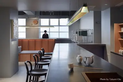 a kitchen with a long wooden table and chairs at KAIKA Tokyo by THE SHARE HOTELS in Tokyo
