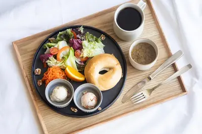 a plate of food with a bagel and a salad at KAIKA Tokyo by THE SHARE HOTELS in Tokyo