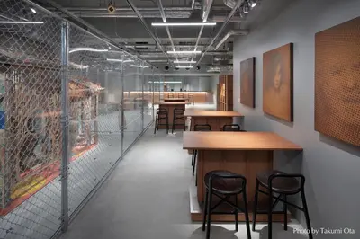 a room with tables and chairs and a fence at KAIKA Tokyo by THE SHARE HOTELS in Tokyo
