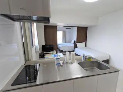 a kitchen with a sink and a room with a bed at CIEL BLEU in Tokyo