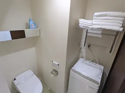a bathroom with a toilet and a sink and towels at CIEL BLEU in Tokyo