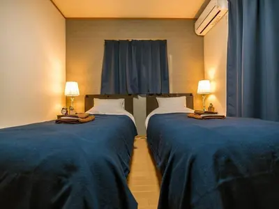 two beds in a hotel room with blue sheets at Katsushika-ku - House / Vacation STAY 5375 in Tokyo
