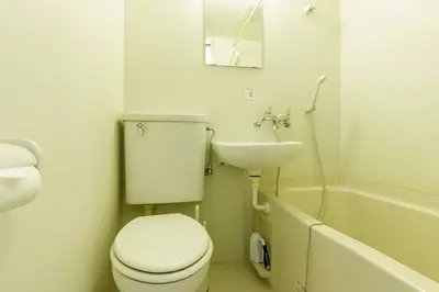 a white bathroom with a toilet and a sink at Hotel Shibuya Shoto in Tokyo