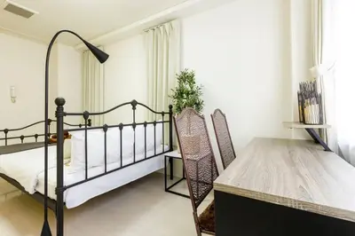 a bedroom with a bed and a table and chairs at Hotel Shibuya Shoto in Tokyo