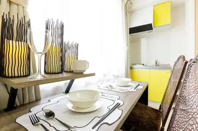 a dining room with a table with chairs and a kitchen at Hotel Shibuya Shoto in Tokyo