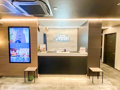 a waiting room with two stools and a tv on the wall at HOTEL LiVEMAX Tokyo Kanda EAST in Tokyo