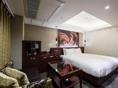 a hotel room with a bed and a couch at Meguroholic Hotel in Tokyo