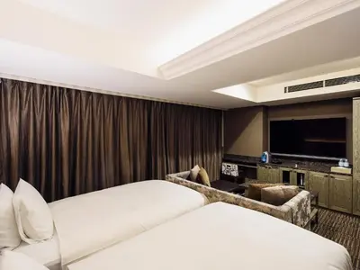 a hotel room with two beds and a flat screen tv at Meguroholic Hotel in Tokyo