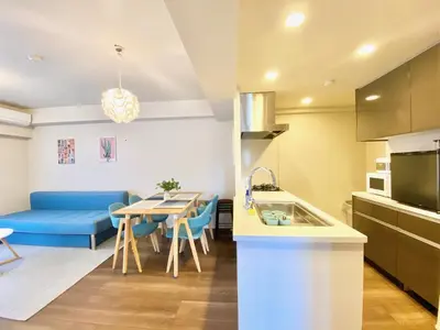 a kitchen and living room with a table and a blue couch at Akasaka Residence in Tokyo