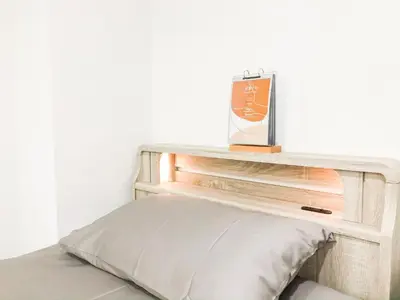 a wooden shelf above a bed with a pillow at ZAITO Tokyo Chitose Accommodation \u68ee\u4e0b\u99c5\u304b\u3089\u5f92\u6b696\u5206 in Tokyo