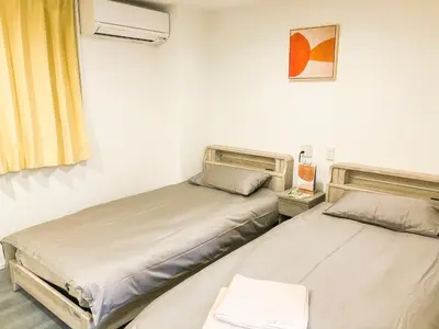 two beds in a room with a window at ZAITO Tokyo Chitose Accommodation \u68ee\u4e0b\u99c5\u304b\u3089\u5f92\u6b696\u5206 in Tokyo