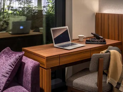 a laptop computer sitting on a wooden desk with two chairs at Mitsui Garden Hotel Toyosu Premier - Tokyo in Tokyo