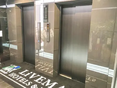 an elevator in a building with a sign on the floor at HOTEL LiVEMAX Shinjuku Kabukicho-Meijidori in Tokyo