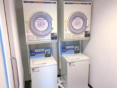a row of automated machines in a room at HOTEL LiVEMAX Shinjuku Kabukicho-Meijidori in Tokyo