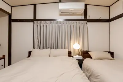 a bedroom with two beds and a window at HIRAI UTOPIA HOTEL in Tokyo