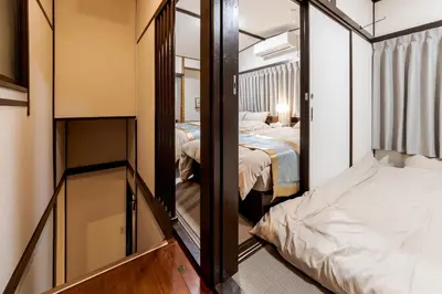 a small room with two beds and a mirror at HIRAI UTOPIA HOTEL in Tokyo