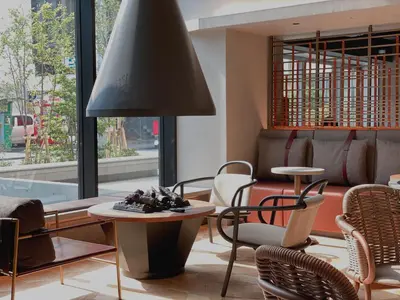 a living room with a table and chairs and a lamp at THE TOURIST HOTEL & Cafe AKIHABARA in Tokyo