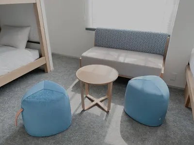 a bedroom with two blue stools and a bed and a table at THE TOURIST HOTEL & Cafe AKIHABARA in Tokyo