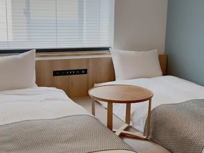 a room with two beds and a table and a window at THE TOURIST HOTEL & Cafe AKIHABARA in Tokyo