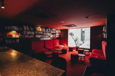 a living room with red furniture and bookshelves at Hotel K5 in Tokyo
