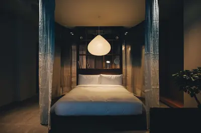 a bedroom with a bed with a chandelier at Hotel K5 in Tokyo