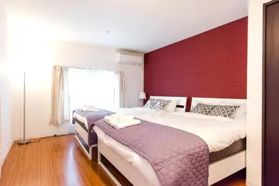 a bedroom with a large bed with a red headboard at Gracias Shibuya - Great Access to Shinjuku & Shibuya in Tokyo
