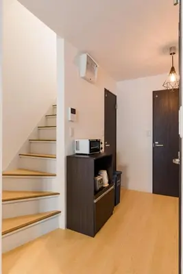 a living room with a staircase with a microwave at Gracias Shibuya - Great Access to Shinjuku & Shibuya in Tokyo