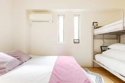 a bedroom with two bunk beds and a ladder at Ishihara House in Tokyo