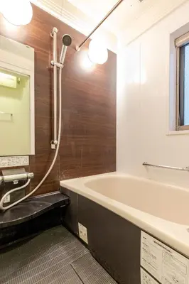 a bathroom with a tub and a sink and a mirror at Ishihara House in Tokyo