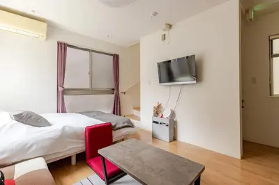 a bedroom with a bed and a tv on a wall at Ishihara House in Tokyo