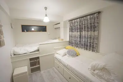 a small room with two beds and a window at 4 bedrooms cozy house, 5 min JR train to Shinjuku, GRADIA Koenji in Tokyo
