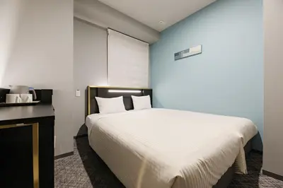 a bedroom with a large white bed and a desk at ICI HOTEL Tokyo Hatchobori in Tokyo