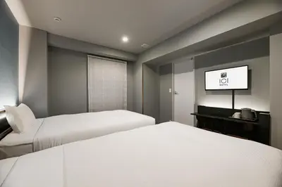 a hotel room with two beds and a flat screen tv at ICI HOTEL Tokyo Hatchobori in Tokyo
