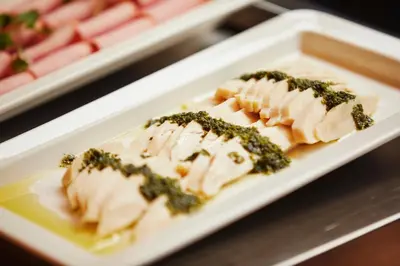 a plate of food with chicken and greens on it at ICI HOTEL Tokyo Hatchobori in Tokyo