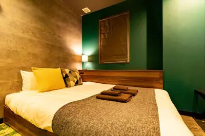 a bedroom with a bed with two towels on it at UNDER RAILWAY HOTEL AKIHABARA in Tokyo