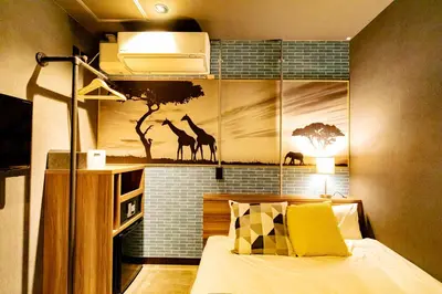 a bedroom with a bed with a mural of giraffes at UNDER RAILWAY HOTEL AKIHABARA in Tokyo