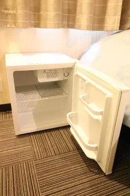 a small refrigerator with its door open in a room at Tokyo Tourist Inn in Tokyo