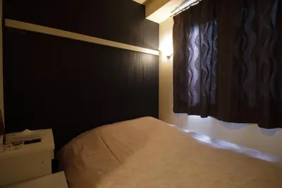 a small bedroom with a bed and a window at Tokyo Tourist Inn in Tokyo
