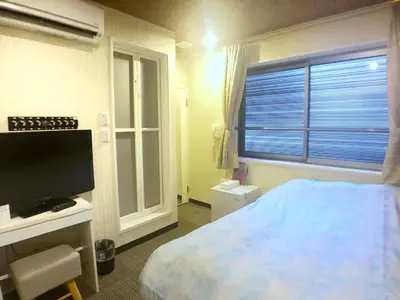 a bedroom with a bed and a flat screen tv at Tokyo Tourist Inn in Tokyo