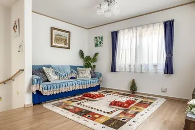 a living room with a blue couch and a rug at Ikebukuro Station 7 minutes by walk 110 sqm villa in Tokyo