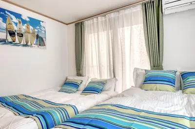 two beds sitting in a room with a window at Ikebukuro Station 7 minutes by walk 110 sqm villa in Tokyo